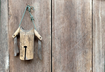 Wood cow bell hanging on wooden wall.