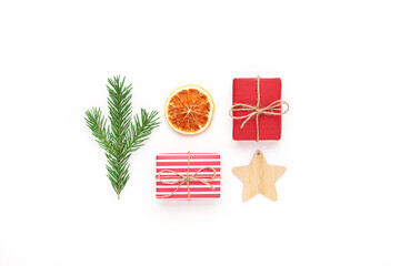 Christmas composition. Flat lay with red gifts, fir tree branch, dry orange and wooden star on white background.