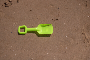 Small green spade on the sand on a beach