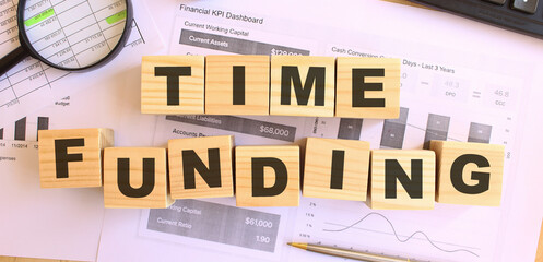Wooden cubes with letters on the table in the office. Text TIME FUNDING . Financial concept.