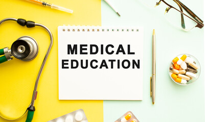 Text MEDICAL EDUCATION on notebook with stethoscope and pen on yellow background.