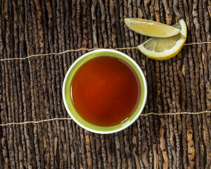 Teacup with lemon on wooden surface