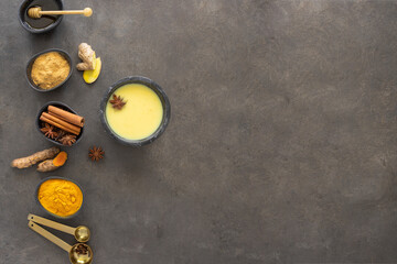 Golden Milk , Ayurvedic beverage with ingredients ginger, turmeric and other  spices on dark...