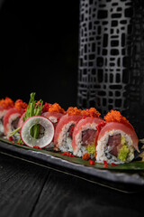 Japanese traditional rolls with tuna, caviar, on a dark table

