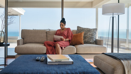 Woman relaxing with digital tablet on luxury home showcase sofa