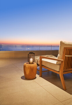 Lantern and side table on luxury patio with sunset ocean view