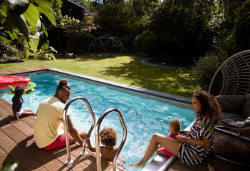 Happy family relaxing at sunny summer poolside patio