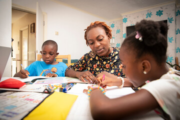 Mother helping kids with homework at dining table