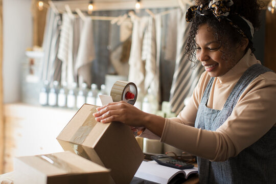 Female shop owner preparing box for shipment