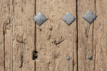 detail of an old wooden door with nails and key hole