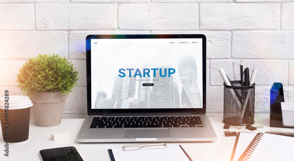 Poster modern laptop with ad of startup platform website on office desk. launching business online concept