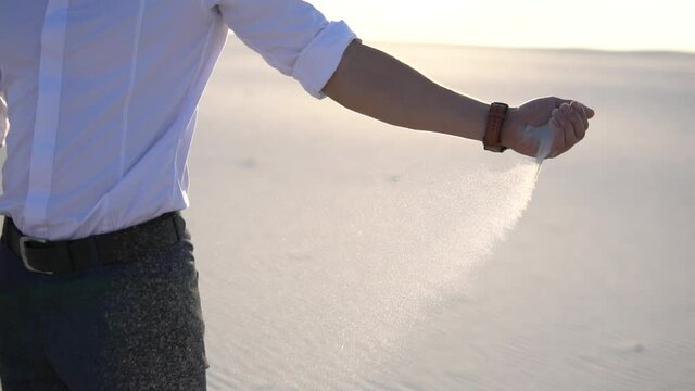Sand falls from the hands of a businessman. High quality FullHD footage