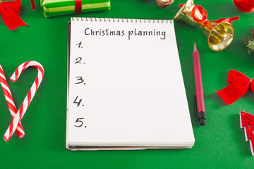 Cristmas Planning Creative Background With Notepad And Holiday Decorations On Green Table