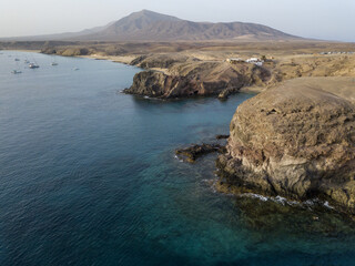 Aerial view of the jagged shores and beaches of Lanzarote, Spain, Canary. Roads and dirt paths. Walking routes to explore the island. Bathers on the beach. Atlantic Ocean. Papagayo
