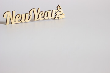 Fototapeta premium wooden inscription new year on a white background in a minimalist style. place for text and design