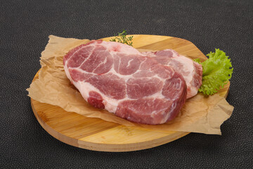 Raw pork steak over wooden board