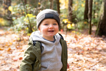 Little toddler boy in autumn park walking lonely