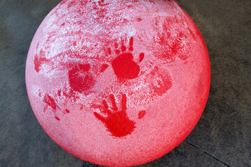 Artistic surface of a red traffic standard with hand prints in the snow.  St Paul Minnesota MN USA