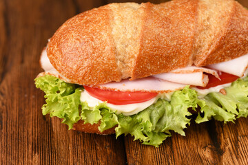 Juicy bread roll with mayo, green salad, tomatoes and ham.