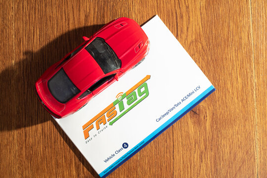 Paytm Payment Bank Issued FASTag RFID Contactless Cashless Payment Tag With Red Model Car On A Wooden Background