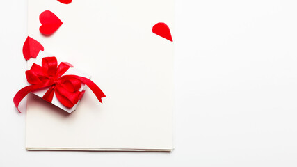 valentines day. gift box on a notebook and red hearts on a white background with copy space. Top View.