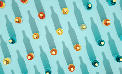 Top view of many closed glass beer bottles mockups standing on turquoise blue background.