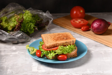Juicy sandwich with mayo, green salad, tomatoes and ham.