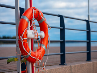 Closeup of an orange life saver buoy on the shore.