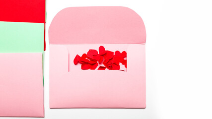 Valentine's Day.Colorful envelopes with small cut paper heart and gift box with red bow. Writing a love letter. Message.Top view.Valentine concept. White background. close up