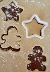 Christmas cookie dough stretched and cut with gingerbread man and stars molds