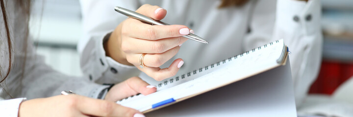 Focus on hardworking people sitting at comfortable workplace and looking at important business...
