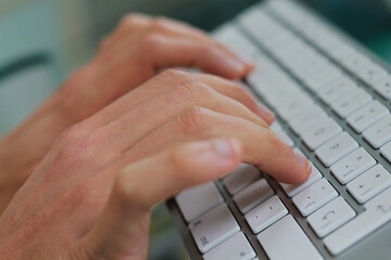 Manos escribiendo en teclado de oficina