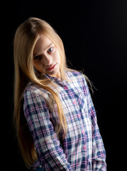 beautiful blonde girl with blue eyes posing in dark background