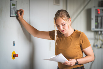 Technisierung in der Landwirtschaft - junge Landwirtin kontrolliert die Steuerung einer...