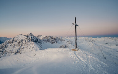 Panoramic view of gorgeous pink sunrise over glacier and high mountain peaks in the Alps. The cross...