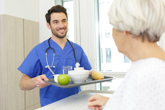 nurse serving a breakfast to patient in hospital - Powered by Adobe