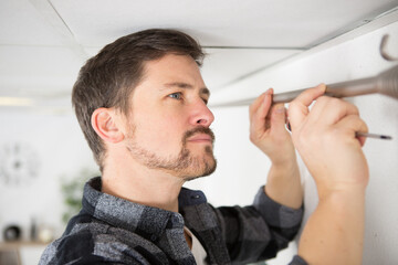 man mounting a curtain rail