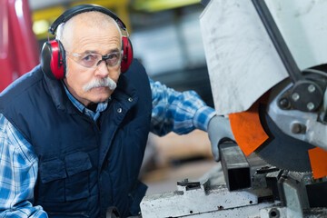 senior worker in factory on the machine