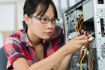 a concentrated young woman working with pc cables