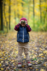 Beautiful young kid looking through binoculars