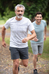 old dad and son running in countryside together