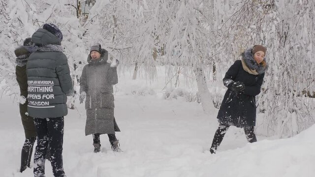 Schoolgirls have fun and celebrate the first snow. Four friends playing in the snow having fun and goofing around after school in the winter.
