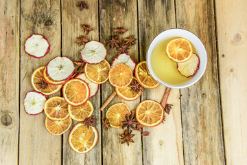 Winter Tee trinken mit weihnachtlicher Dekoration mit Apfel- und Orangenscheiben und Gewürzen wie Anis und Zimtstangen