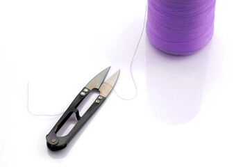 Thread cutter, sewing equipment. Metal scissors-nippers not against white background. A skein of...