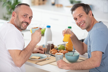 homosexual couple having breakfast at home