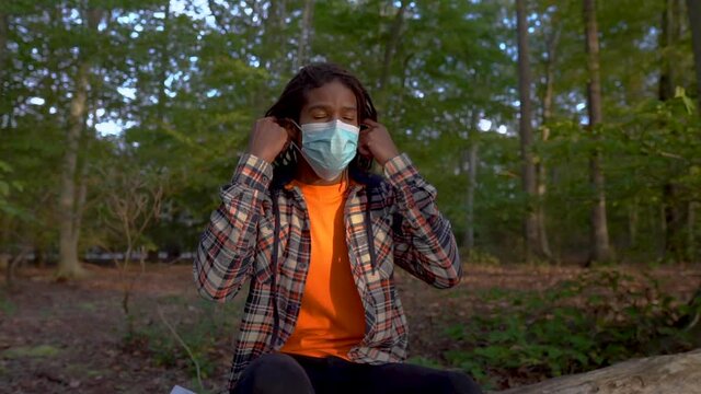 Gen Z Man Takes Off Coronavirus Face Mask Outdoors and Opens Book