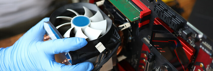 Close-up of middle-aged man repairing detail of device. Technician male fixing computer mainboard....
