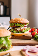 Two home made fresh tasty burgers with lettuce and cheese.