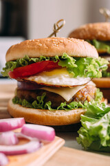 Two home made fresh tasty burgers with lettuce and cheese.