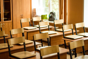 Empty school class, wooden chairs stand on the desk